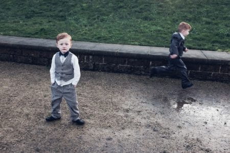 Pageboy standing with hands in pockets as another boy runs past - Picture by Shaun Carr Photography