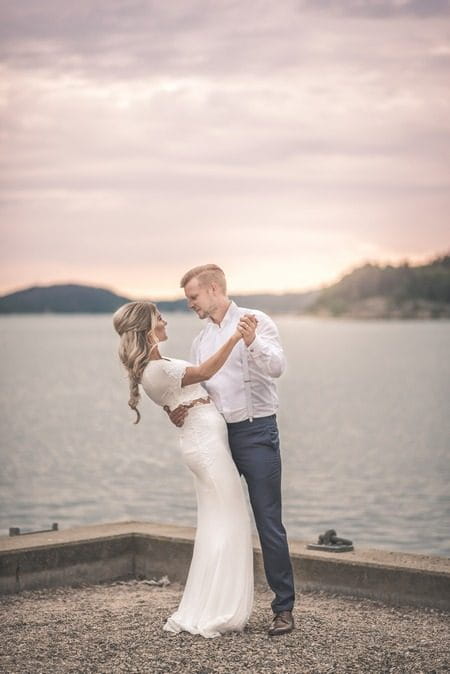 Bride and groom holding each other next to water - Picture by Natalie Johansson Fotograf