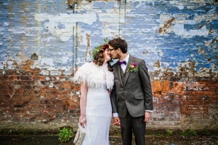 Bride and groom kissing in front of a wall - Picture by Sarah Janes Photography