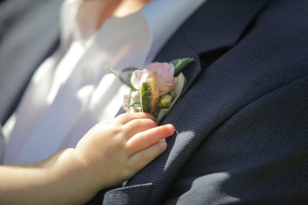 Baby's hand touching buttonhole