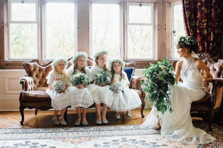 Flower girls sitting on couch next to bride in chair - Picture by Helen Russell Photography