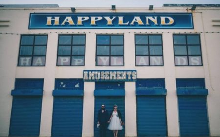 Bride and groom standing outside Happyland Amusements - Picture by Naomi Jane Photography