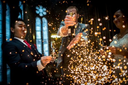 Wedding guests holding bottle of Champagne with explosion of sparks in front of them - Picture by James Tracey Photography