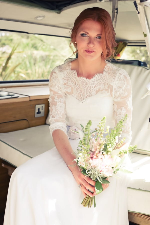 Bride holding bouquet in back of camper van