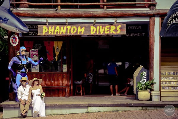 Bride and groom sitting outside Phantom Divers in Mexico