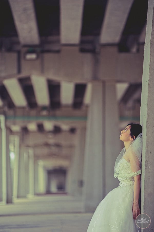 Bride leaning against pillar