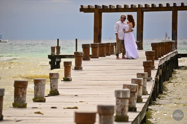 Bride and groom walking along jetty