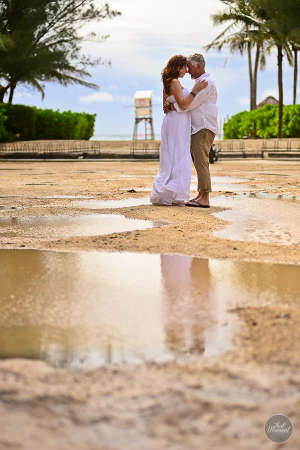 Bride and groom standing by puddle