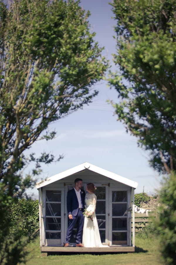 Bride and groom standing outside summer house