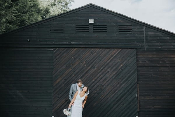 Bride and groom in front of large wooden building at Colshaw Hall