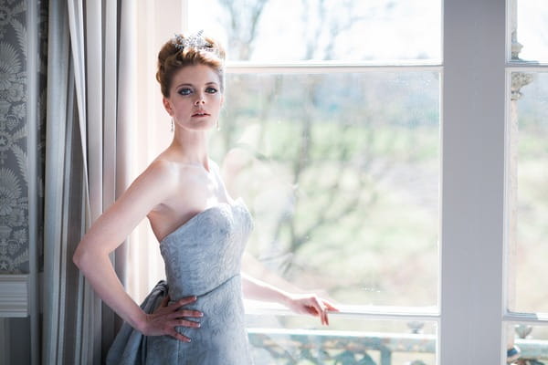 Bride standing by window in The Duke of Cornwall Hotel