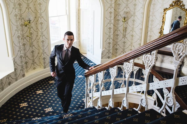 Groom walking up The Duke of Cornwall Hotel stairs