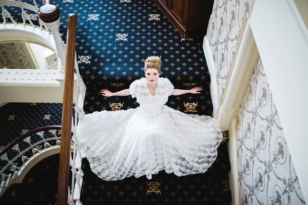 Bride sitting on of The Duke of Cornwall Hotel stairs