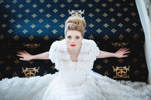 Bride looking up mas she sits on The Duke of Cornwall Hotel stairs