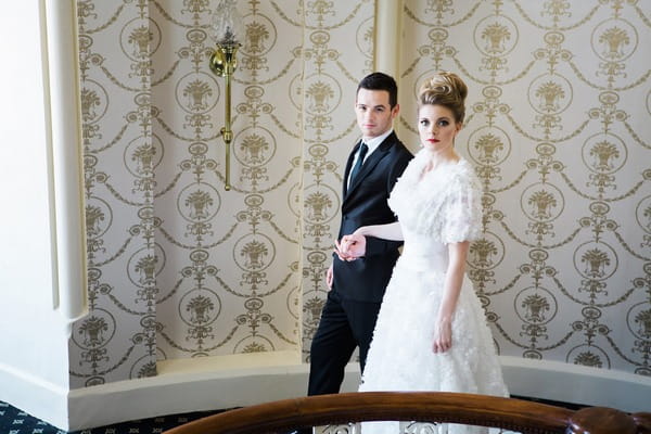 Bride and groom holding hands on The Duke of Cornwall Hotel stairs