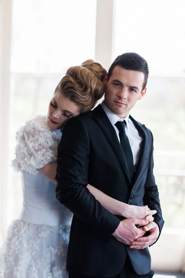 Bride hugging groom from behind