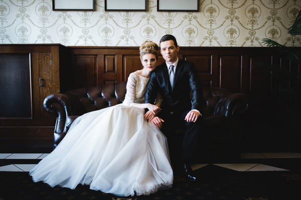 Bride and groom sitting on sofa in The Duke of Cornwall Hotel