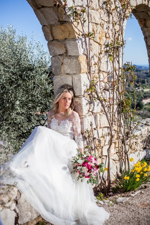 Bride sitting on wall