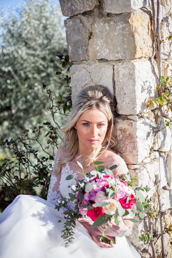 Bride sitting holding bouquet