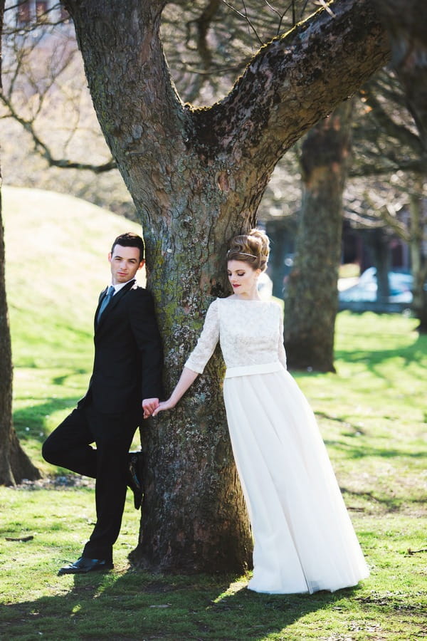 Bride and groom by tree