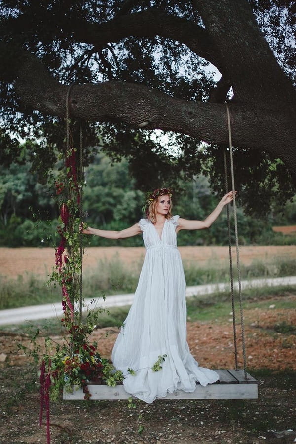 Boho bride standing on swing