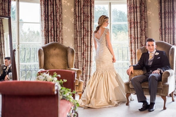 Bride and groom in bedroom at Wyck Hill House