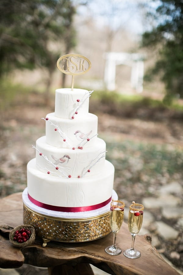 White wedding cake with birds and berry detail