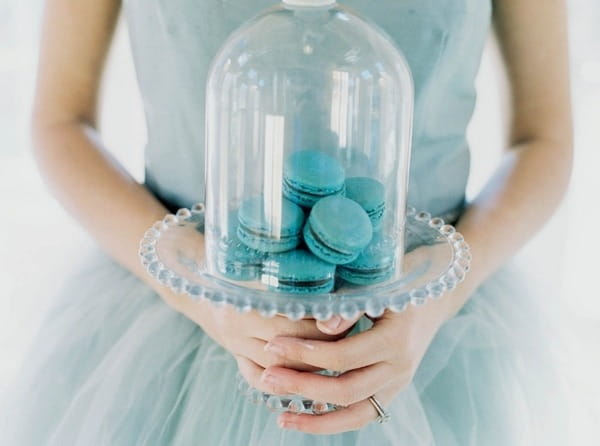 Bride holding macaroons under cloche