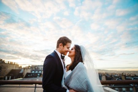 Bride and groom about to kiss on balcony in Scotland - Picture by The Gibsons