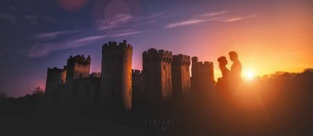 Silhouette of bride and groom with sun going down next to castle - Picture by David West Photography