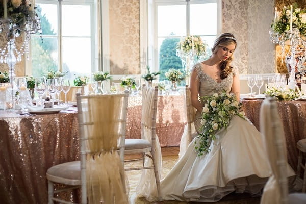 Bride sitting in Wyck Hill House holding bouquet