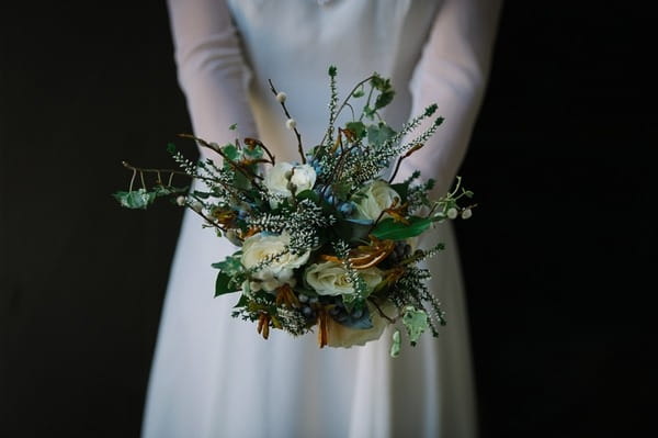 Bride holding out winter wedding bouquet