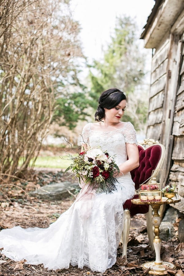 Bride sitting on chair in woods