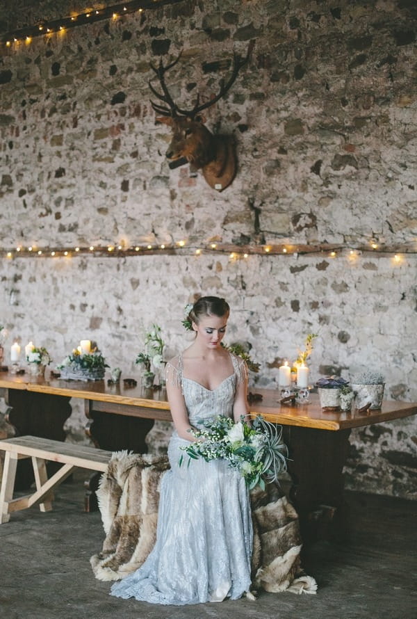 Bride sitting on bench at table