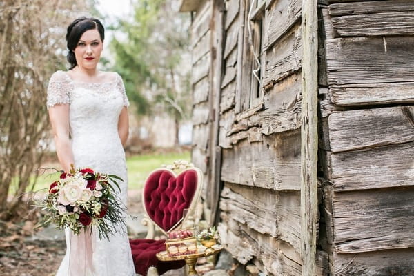 Bride standing next to red chair