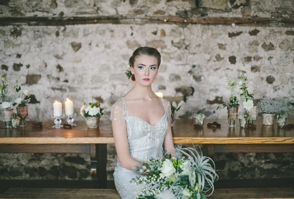 Bride sitting at table with bouquet