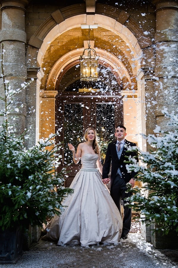 Bride and groom in snow outside Wyck Hill House