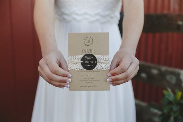 Bride holding rustic wedding invitation