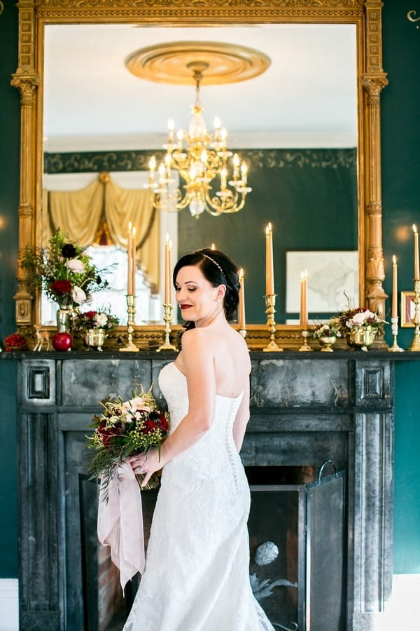 Bride standing in front of fireplace