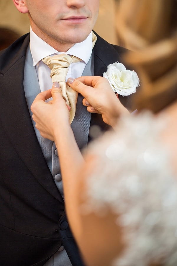 Bride adjusting groom's cravat