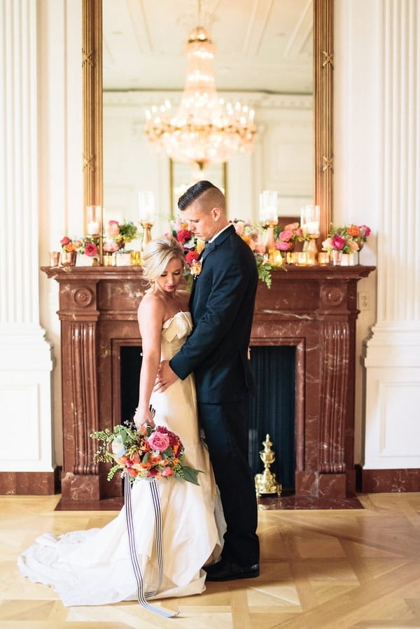 Bride and groom in front of fireplace