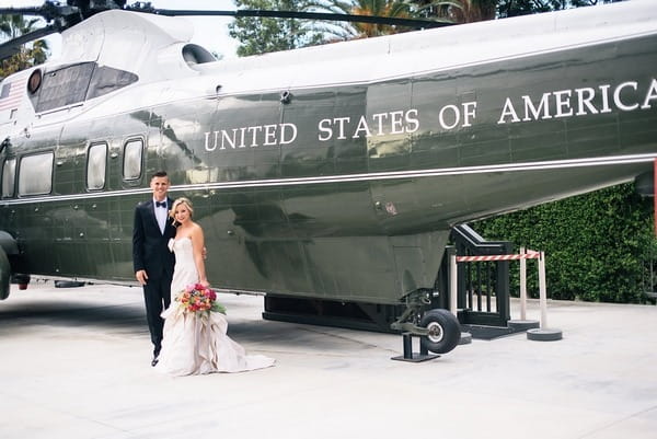 Bride and groom in front of military helicopter