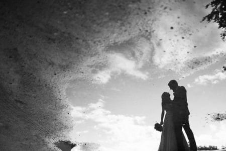 Reflection of bride and groom in puddle - Picture by Jay Emme Photography