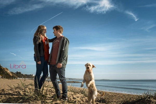 Couple on Branksome Beach with dog jumping into picture