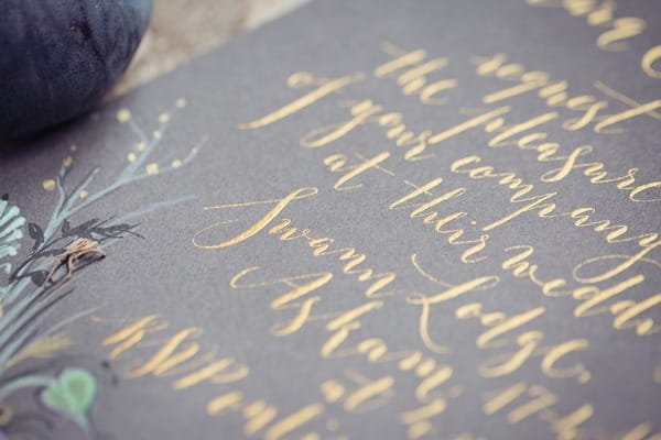 Gold calligraphy on slate wedding stationery