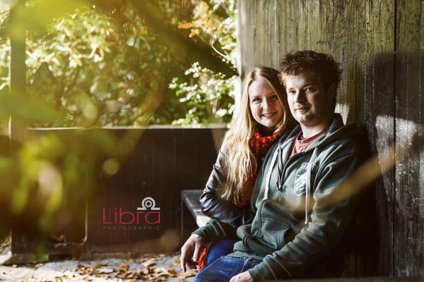 Couple sitting on bench in shelter