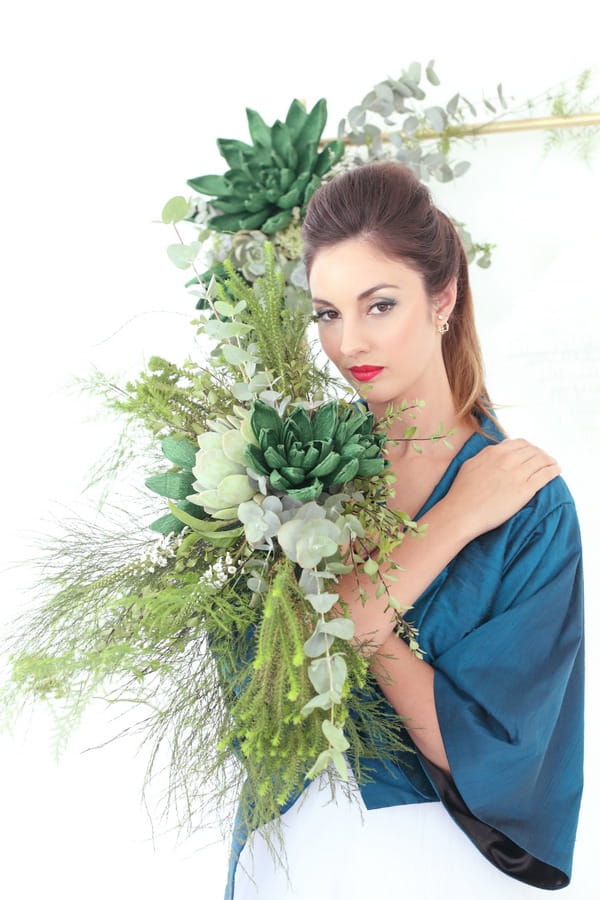 Bride holding succulents and foliage bouquet