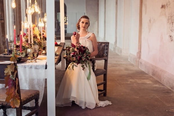 Bride sitting in chair at wedding table