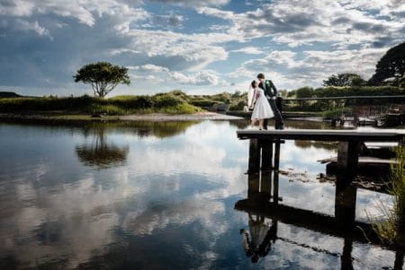 Bride and groom on jetty at Christchurch Harbour - Picture by Libra Photographic