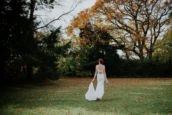 Bride walking across garden of Deer Park